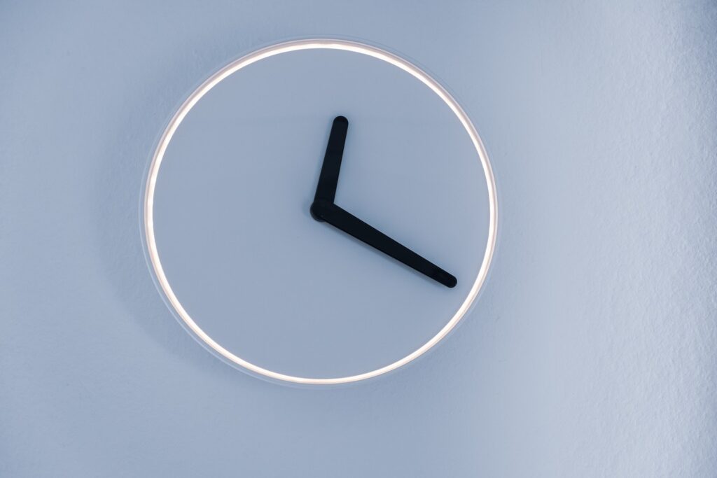 minimalist analog clock on blue-grey wall