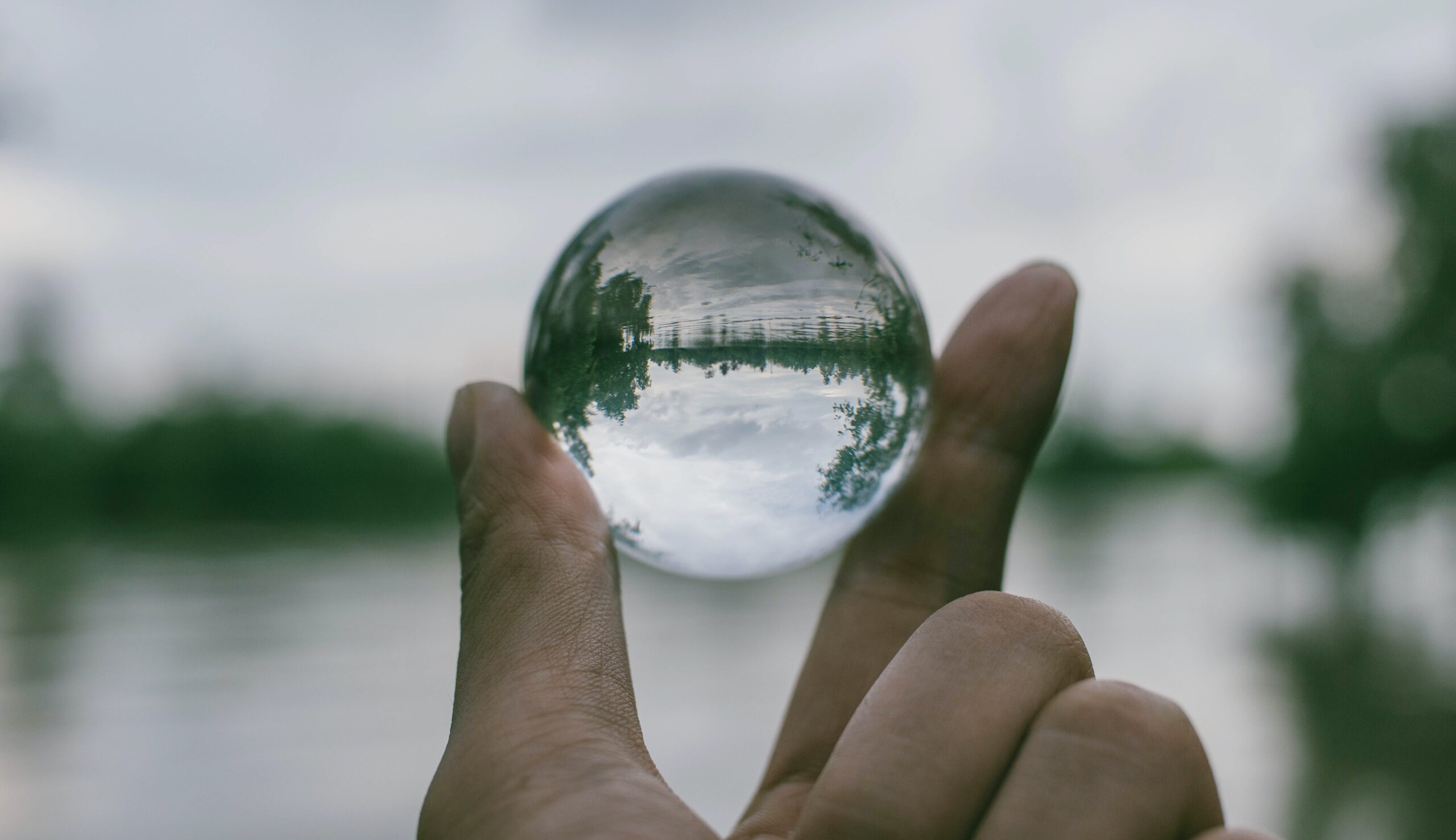 close up of fingers holding a crystal ball
